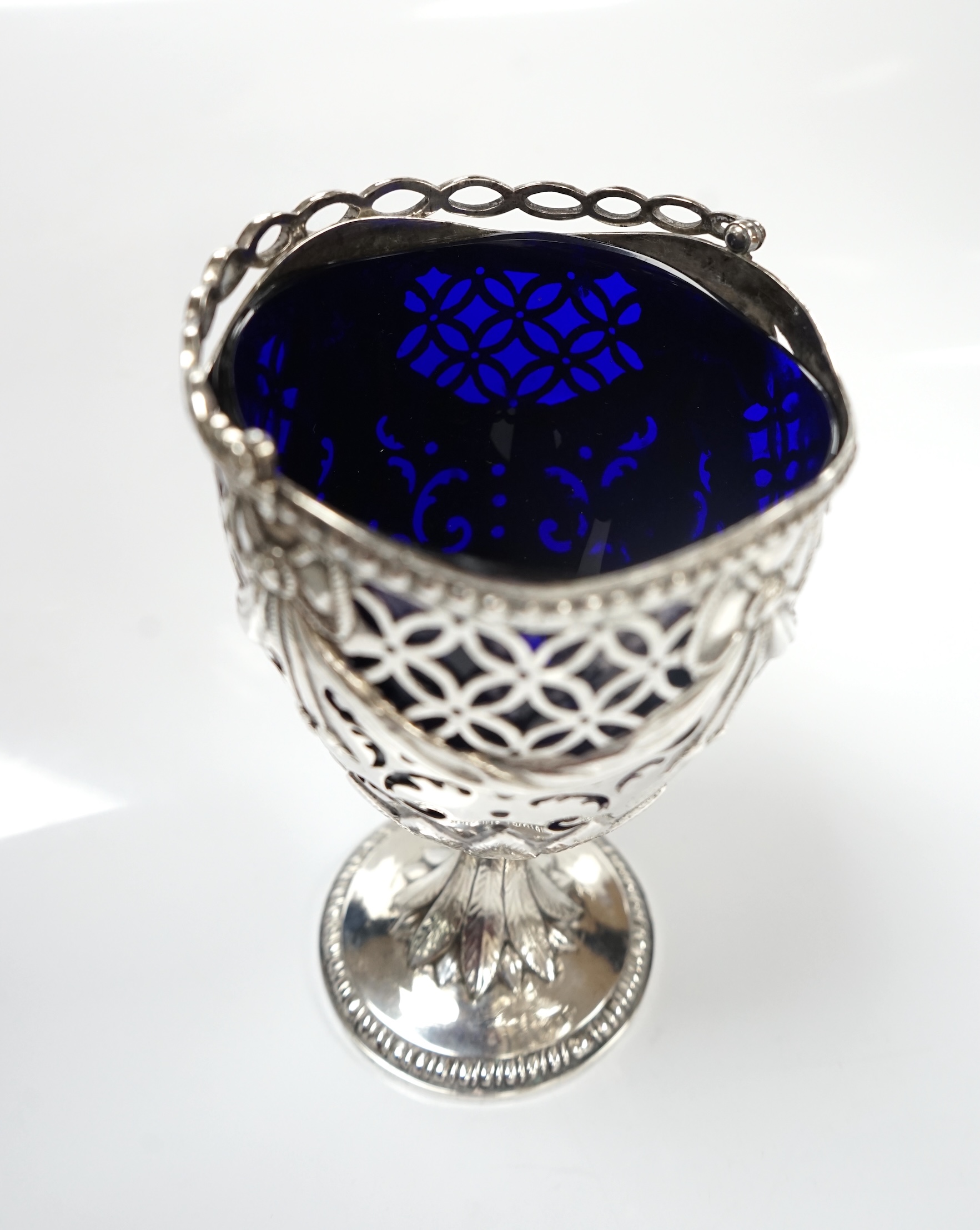 A George III silver pedestal sugar basket, with blue glass liner, indistinct marks, height 12.4cm. Condition - fair